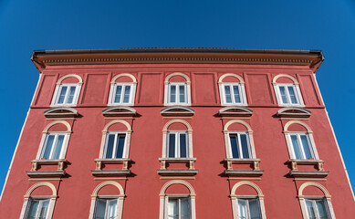 Fototapeta na wymiar Part of an old multi-storey building in red.