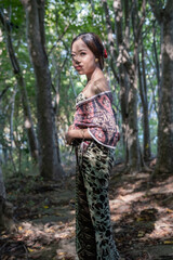 Balinese girl posing in nature and in a forest on Candidasa's offshore islands in Bali, dressed in a traditional costume. 