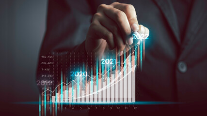 Businessman or trader year showing glowing virtual technical investment graph chart for analysis...