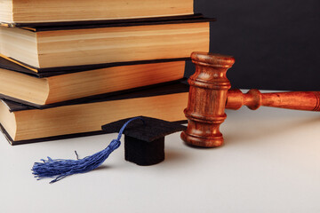 Stack of books, academic cap and gavel on the table
