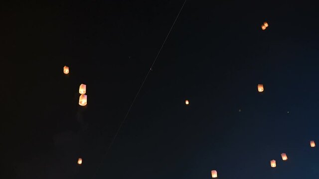 Floating lanterns in the night sky. Launching Sky Lantern. Yee Peng Festival, Loy Krathong celebration in Chiang mai, Thailand.