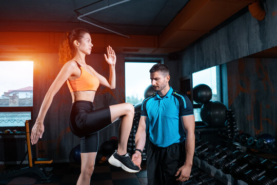 Athlete Female Has Exercising Lunges On Step Box With Personal Trainer In Gym