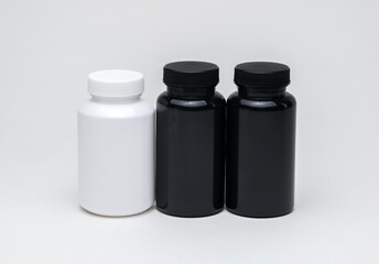 White and black plastic pill jars on a white background. Isolated