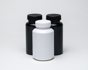 White and black plastic pill jars on a white background. Isolated