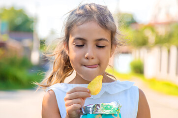 The child is eating chips. Selective focus.