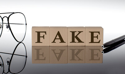 Close-up Of FAKE Wooden Blocks on the black background with glasses and pen