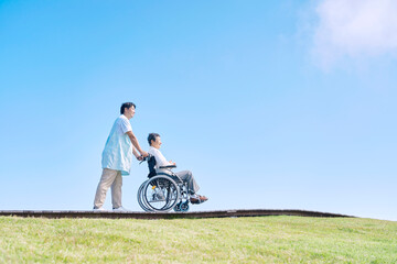 高齢者の車椅子を押す介護士