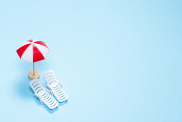 Travel concept. Sun lounger, red umbrella on a blue background.