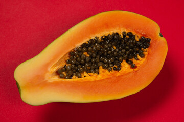 Papaya fruit on a orange background. Half papaya.