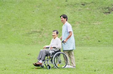 高齢者の車椅子を押す介護士