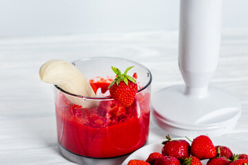 Making smoothie from a fresh, ripe strawberry 