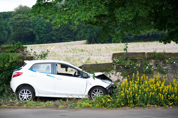 Car crash in rural countryside and damaged wall