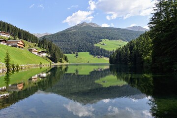 Lago di Valdurna in AltoAdige cielo serene e riflessi sulla superficie, chiesa tipica con campanile...