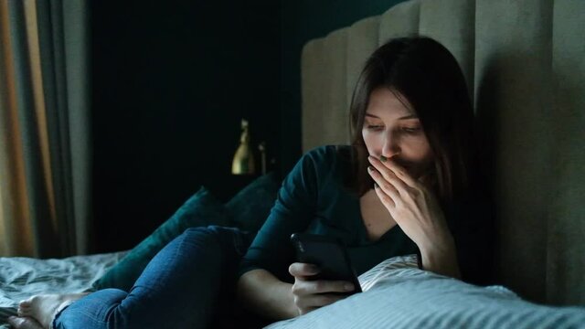 The girl reads the bad news on the phone. Woman watching scary video on phone