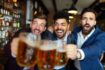 Business men in pub cheering for a sporting event