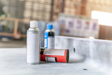Cans of spray Penetrant Testing on on material steel and blur factory in background