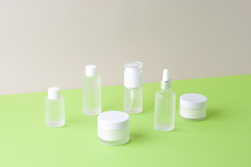 Cosmetic skin care products on green and grey background. Close up, copy space