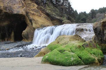 Beautiful foamy waterfall in Hug Point State Recreation Site, a state park in Arch Cape, Oregon