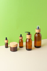 Cosmetic skin care products on green and beige background. Close up, copy space