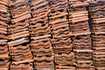 Stacks of used red ceramic roofing tiles