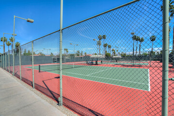 Empty tennis court under a blue cloudless sky