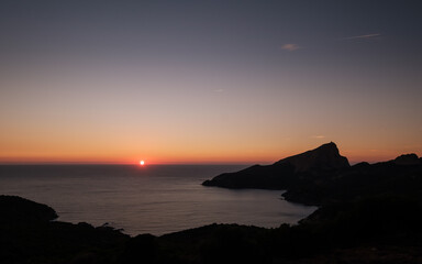 Sun setting over the Genoese tower of Tour de Turghiu sitting on Capo Rosso on the west coast of Corsica