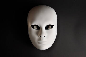 White theatrical mask and playing dice