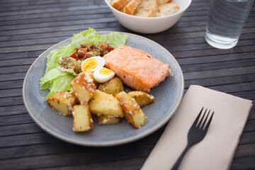 baked salmon fillet with fried potato wedges, homemade guacamole and quail eggs halves