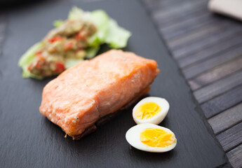 baked salmon fillet with homemade guacamole and quail eggs halves