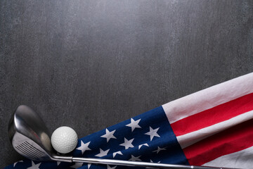 Golf ball and golf club with flag of USA on black table background, sport concept