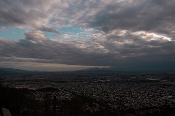 Paisaje de la ciudad vista desde las montañas durante el atardecer en un dia nublado