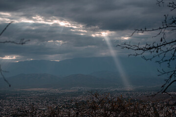 Sunlight and rainbow over the mountains on a cloduy day