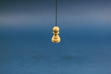 The promised pawn. Pawn suicide. Blue background.