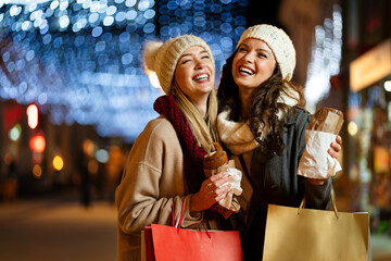 Christmas shopping people concept. Happy young women with shopping bags buying presents