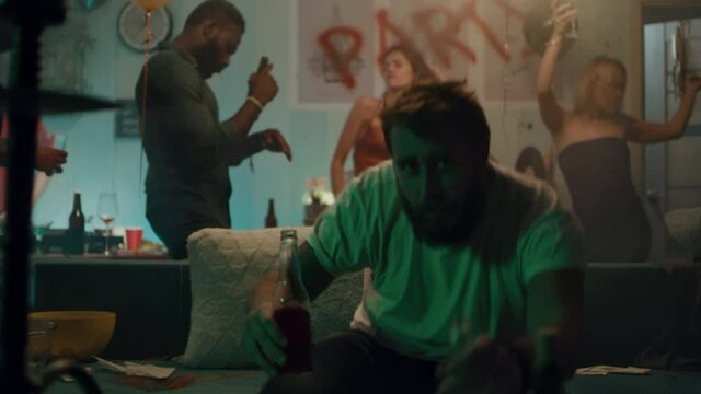 Man drinking alcohol during party on sofa