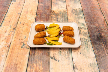 Serrano ham croquettes serving with homemade chips served as tapas in a Spanish restaurant
