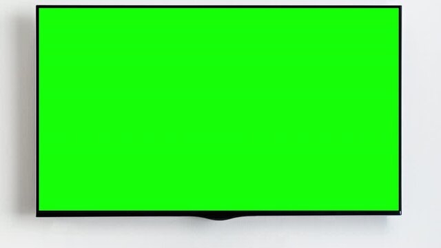 Tv with blank green screen in modern home interior in living room. Zoom out. Ideal for advertising and marketing of online streaming platforms and services with shows and films