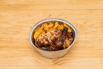 Medium Roast Chicken with Toasted Skin and Garnish of Homemade French Fries in a Circular Aluminum Takeout Container
