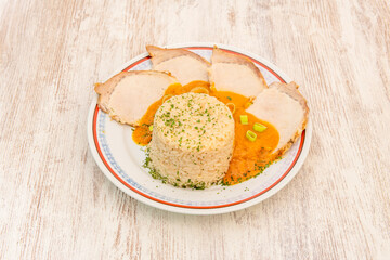 roasted pork loin fillets garnished with cooked white rice and pumpkin cream with vegetables and parsley