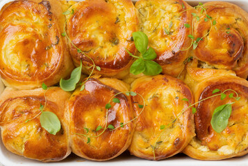 Buns with feta cheese and basil of yeast dough on a light wooden background. Selective focus. Rustic style.Top view
