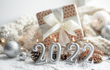 Fototapeta na wymiar Christmas background with candles in the form of numbers 2022 and a gift box.
