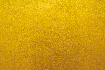 Gold wall texture background. Yellow shiny gold foil paint on wall sheet © merrymuuu
