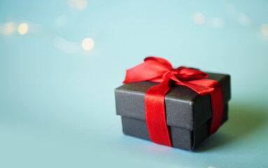 Gift bow with red ribbon bow on blue background. Holidays present. Celebration concept. 