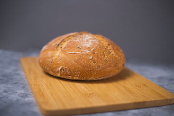 loaf of bread on cutting board isolated on gray background