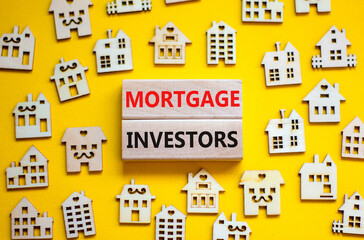 Mortgage investors symbol. Concept words 'Mortgage investors' on wooden blocks near miniature wooden houses. Beautiful yellow background. Business, mortgage investors concept.