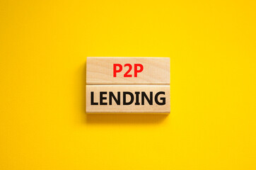 P2P peer to peer lending symbol. Concept words P2P lending on wooden blocks on a beautiful yellow background. Business and P2P peer to peer lending concept. Copy space.