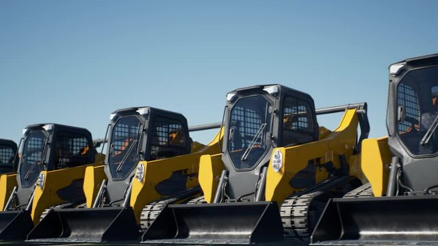 An endless row of mini loaders. Construction machinery fleet ready for heavy work. Looping animation. 4K UHD