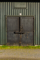 Bolted and shut door on a green storage shed.