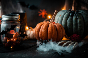 Halloween background. Orange and grey pumpkins surrounded by spider web and flying bats backlit...