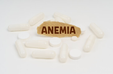 On a white background pills and a piece of paper with the inscription - ANEMIA